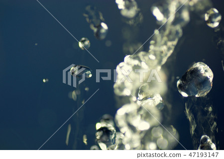 Abstract macro photo of water drops fly in the air levitation water on blue background. 47193147