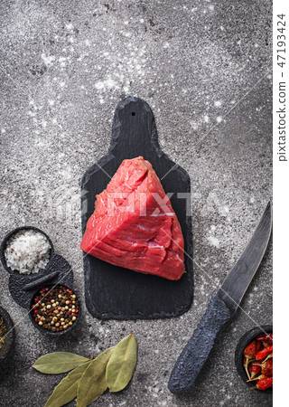 Raw meat on cutting board with spices 47193424