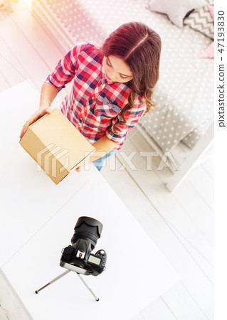 Cute and funny little blogger feeling curious while getting her present box Cute and funny little blogger feeling curious while getting her present box 47193830