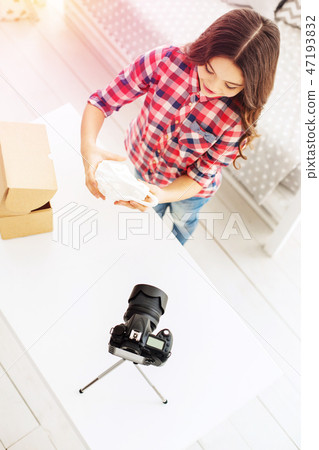 Top view of stylish little girl telling about her presents on camera filming video Top view of stylish little girl telling about her presents on camera filming video 47193832