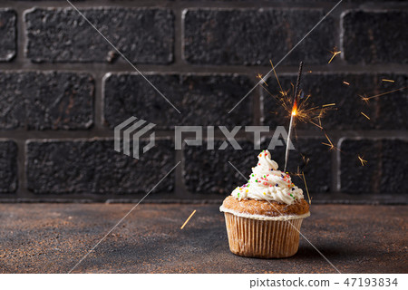 Birthday cupcake with cream and sparkler Birthday cupcake with cream and sparkler 47193834