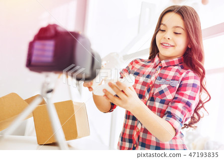 Stylish and beautiful curly girl standing in front of her camera while filming blog 47193835