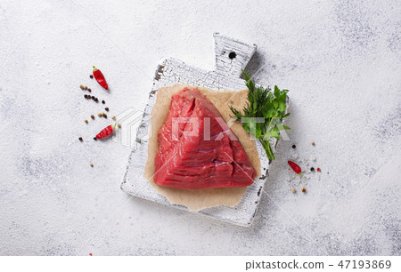Raw meat on cutting board with spices 47193869
