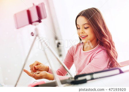 Pleasant cute dark-haired schoolgirl using phone sand while filming video 47193920