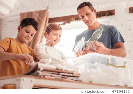Diligent father speaking with his sons about waste classification 47194331