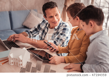 Smart devoted father telling his sons about renewable energy 47194359