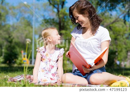 girl and a young woman reading a book together girl and a young woman reading a book together 47199123