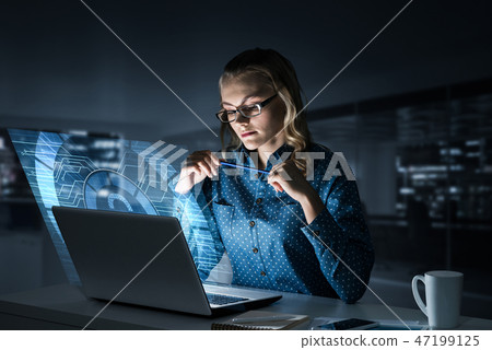 Beautiful blonde in dark office working on laptop and getting ne Beautiful blonde in dark office working on laptop and getting ne 47199125