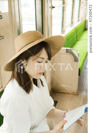 Woman reading a book on a train Woman reading a book on a train 47200472