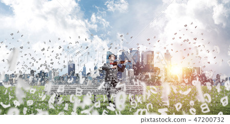 Handsome violinist in park on wooden bench and symbols fly around Handsome violinist in park on wooden bench and symbols fly around 47200732