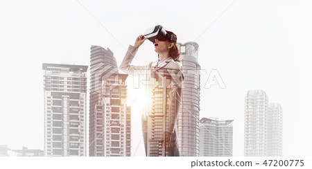 Woman in mask against sunrise above city trying virtual reality 47200775
