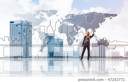 Sunrise above skyscrapers and engineer in helmet drawing globali Sunrise above skyscrapers and engineer in helmet drawing globali 47202772