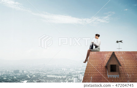 Businesswoman or accountant on house roof floating high above mo Businesswoman or accountant on house roof floating high above mo 47204745