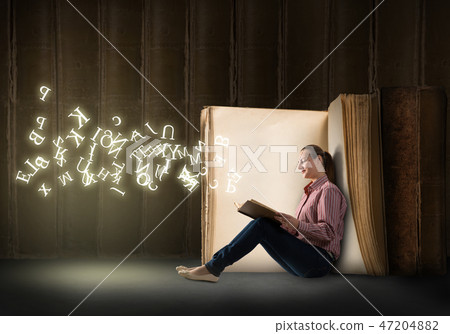 young woman reading a book 47204882