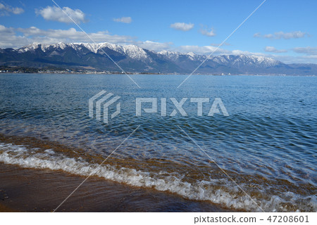 Snowy mountain range and clear lake in clear blue sky 47208601