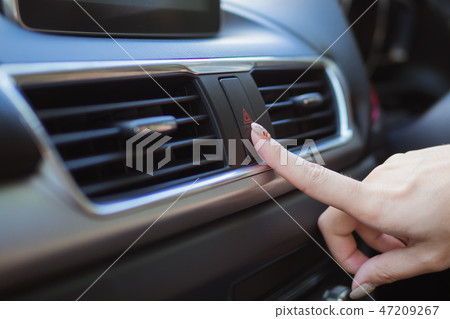Close up finger hitting car emergency light button Close up finger hitting car emergency light button 47209267