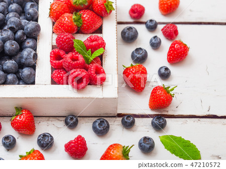 Fresh raw organic berries in white wooden box Fresh raw organic berries in white wooden box 47210572