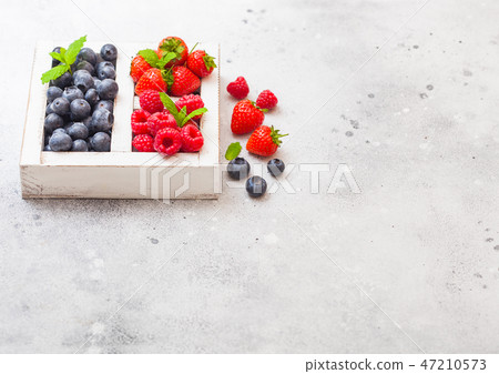 Fresh raw organic berries in white wooden box Fresh raw organic berries in white wooden box 47210573