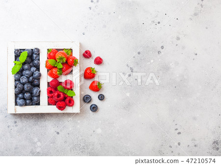 Fresh raw organic berries in white wooden box Fresh raw organic berries in white wooden box 47210574