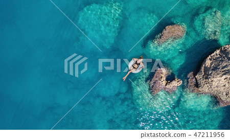 Aerial view at the girl on sea surface. Aerial view at the girl on sea surface. 47211956