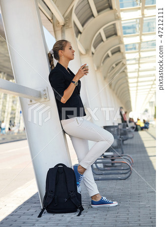 young urban woman drinking coffee in european city. Travel tourist woman with hot drink 47212111