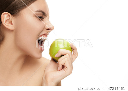 portrait of attractive caucasian smiling woman isolated on white studio shot eating green apple portrait of attractive caucasian smiling woman isolated on white studio shot eating green apple 47213461