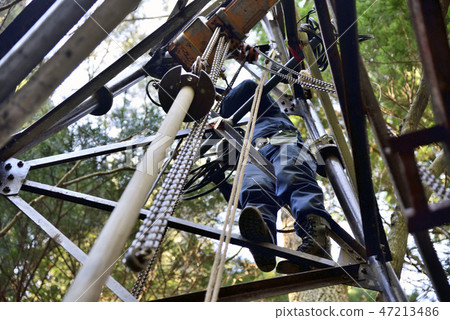 Working at heights: A craftsman above the tower exchanging pipes for pumping hot springs 47213486