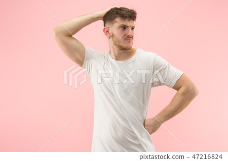 Beautiful man looking suprised and bewildered isolated on pink Beautiful man looking suprised and bewildered isolated on pink 47216824