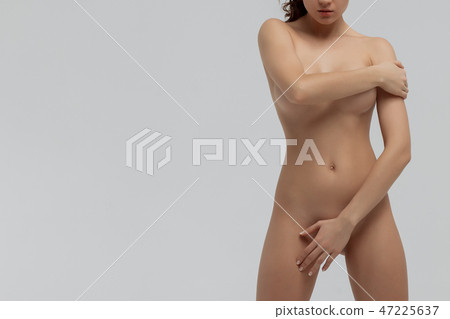 Beautiful slim woman covering her nude breast isolated on white background 47225637