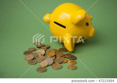 euros coins falling from yellow piggy bank 47225884