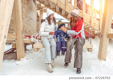 Two friends of classmate swing on wooden swing, in place with a young son of 3-5 years old or nephew Two friends of classmate swing on wooden swing, in place with a young son of 3-5 years old or nephew 47226703