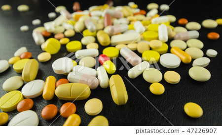 Drugs scattered on a black table Drugs scattered on a black table 47226907
