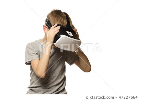 Boy experiencing virtual reality head bowed Boy experiencing virtual reality head bowed 47227664