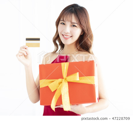 smiling Asian woman showing credit card and gift smiling Asian woman showing credit card and gift 47228709
