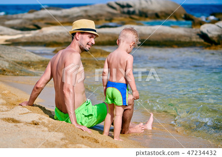 Toddler boy on beach with father Toddler boy on beach with father 47234432