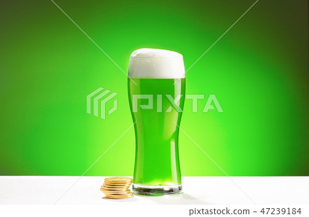 Glass of fresh cold green beer on a wooden bar counter in pub. 47239184