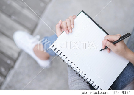 Top view female hands with pen writing on notebook 47239335