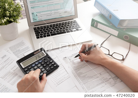 Accountant working with US tax forms Accountant working with US tax forms 47240020