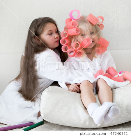 Pink hair curlers in the hair of a Caucasian girl. Pink hair curlers in the hair of a Caucasian girl. 47240351