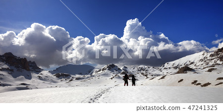 Panoramic view on snowy plateau with two hikers Panoramic view on snowy plateau with two hikers 47241325