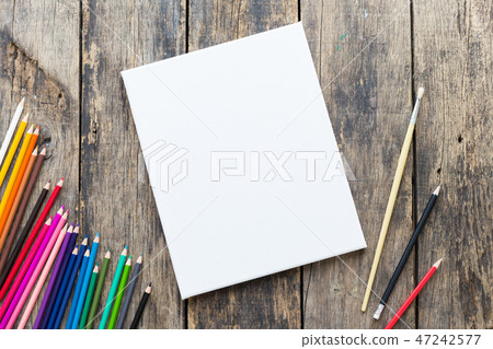 Blank paper and colorful pencils on old wooden tab Blank paper and colorful pencils on old wooden tab 47242577