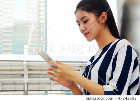 Beautiful woman smile portrait and playing mobile Beautiful woman smile portrait and playing mobile 47242582