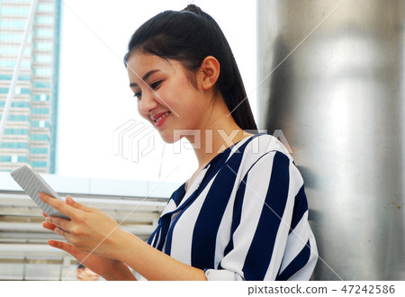 Beautiful woman smile portrait and playing mobile. Beautiful woman smile portrait and playing mobile. 47242586