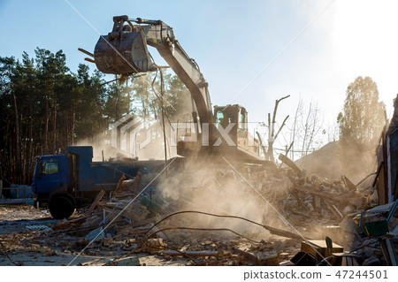 Excavator demolishing building 47244501