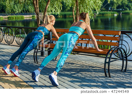 girls doing exercises on the sports field girls doing exercises on the sports field 47244549