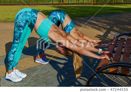 girls doing exercises on the sports field girls doing exercises on the sports field 47244550