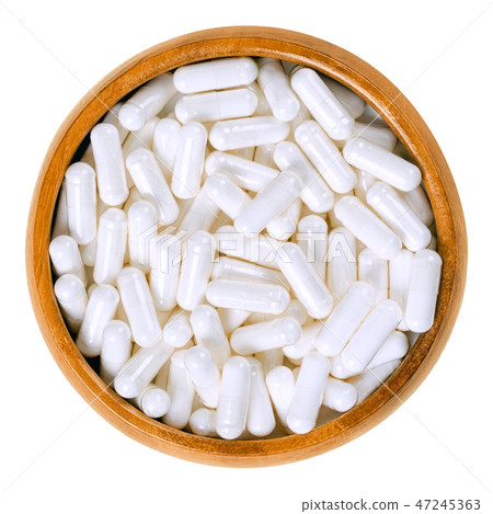 White food supplement capsules in wooden bowl White food supplement capsules in wooden bowl 47245363