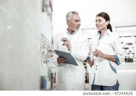 New pharmacist listening to her boss while having her first day at work New pharmacist listening to her boss while having her first day at work 47245626