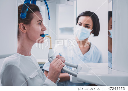 Serious brunette female person holding medical instrument Serious brunette female person holding medical instrument 47245653