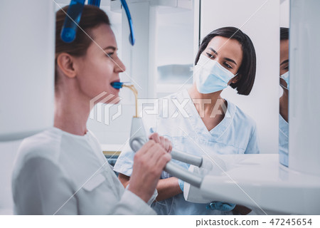 Cheerful stomatologist doing x-ray picture of teeth Cheerful stomatologist doing x-ray picture of teeth 47245654
